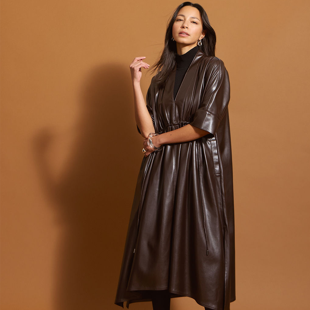 Woman wearing the chocolate brown leather dress against a brown background.