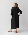 Rear shot of Carla wearing shirt dress at the back in black, highlighting the garment’s relaxed fit.