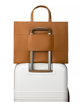 2-in-1 Tote Bag in Caramel showing the luggage sleeve in a suitcase.