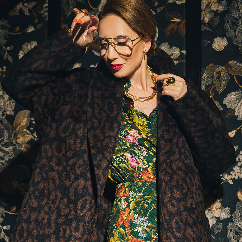 Carla modeling the Leopard Jacquard coat on a florald background.