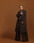 Person wearing the Leopard Jacquard coat with a pattern on a brown background.