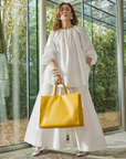 Carla Rockmore modeling the 2-IN-1 TOTE BAG in SAFFRON.