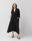 Carla Rockmore wearing the Everywhere Everyday Shirt Dress in black, striking a fun, animated pose with one hand casually tucked into the dress pocket, showcasing its functionality and relaxed elegance.