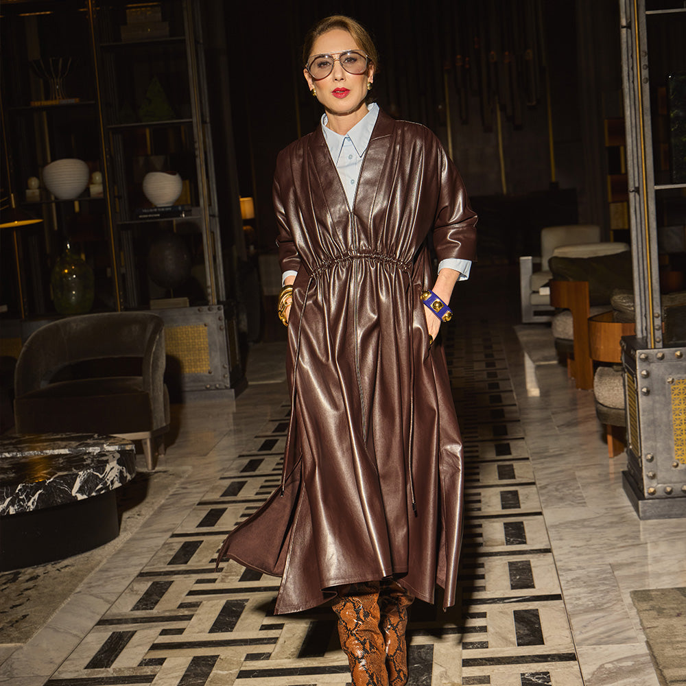 Carla in the Everywhere Everyday Dress Chocolate Brown standing in an elegant interior setting.