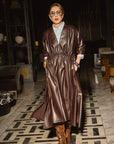 Carla in the Everywhere Everyday Dress Chocolate Brown standing in an elegant interior setting.