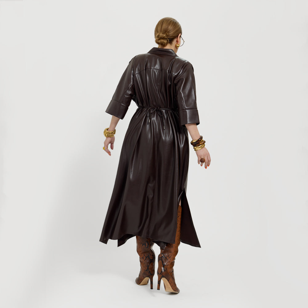 Carla wearing the chocolate brown vegan leather dress showing the back of the dress on a white background.