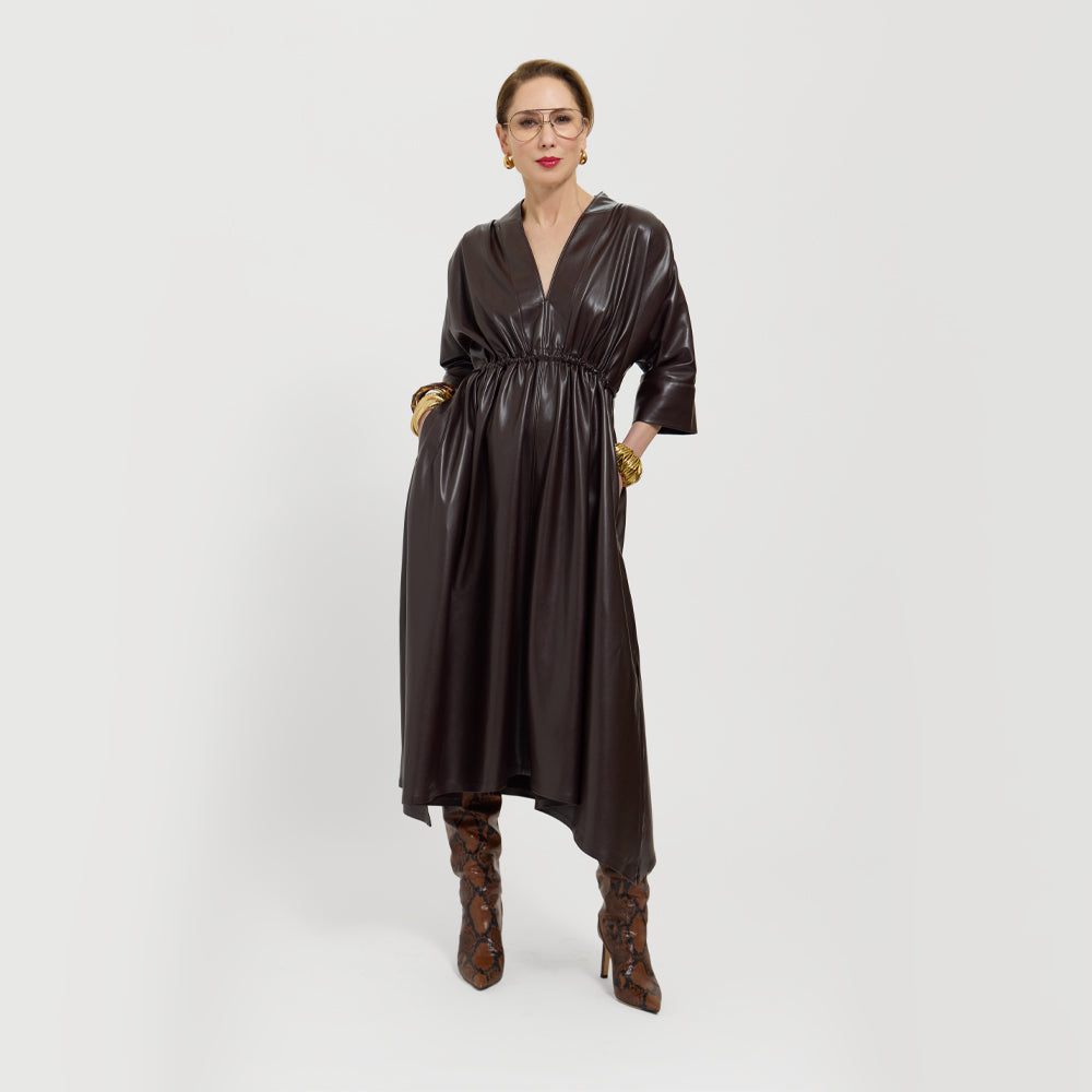Carla wearing the chocolate brown dress and high-heeled shoes on a white background.