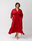 Model wearing the Everywhere Everyday Shirt Dress in Poppy, front-facing with the waist untied for a loose, relaxed silhouette, paired with beige heels against a neutral backdrop.