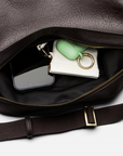 Mini Sling Bag in Chocolate with phone, wallet, and keys on a white background.