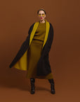 Carla modeling the coat in black and you see the inside of the coat in moss.