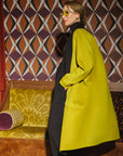 Carla modeling the side and the back of the coat in Moss.