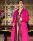 Carla in the Indispensable Car Coat Wool Blend in Orchid over a the vegan leather dress in Merlot an elegant room with decorative elements as background.