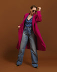 Carla wearing the Indispensable Car Coat Wool Blend in Orchid and blue jeans on a brown background.