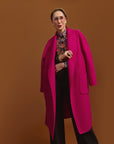 Carla in the Indispensable Car Coat Wool Blend in Orchid against a brown background.