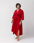Model striking a side pose in the poppy dress, styled with heeled sandals, showcasing a polished, elevated look with fluid movement in the fabric.