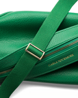 Zoomed-in view of the Mini Sling Bag in emerald green, highlighting the pebbled texture of the material and the woven strap’s detailing.