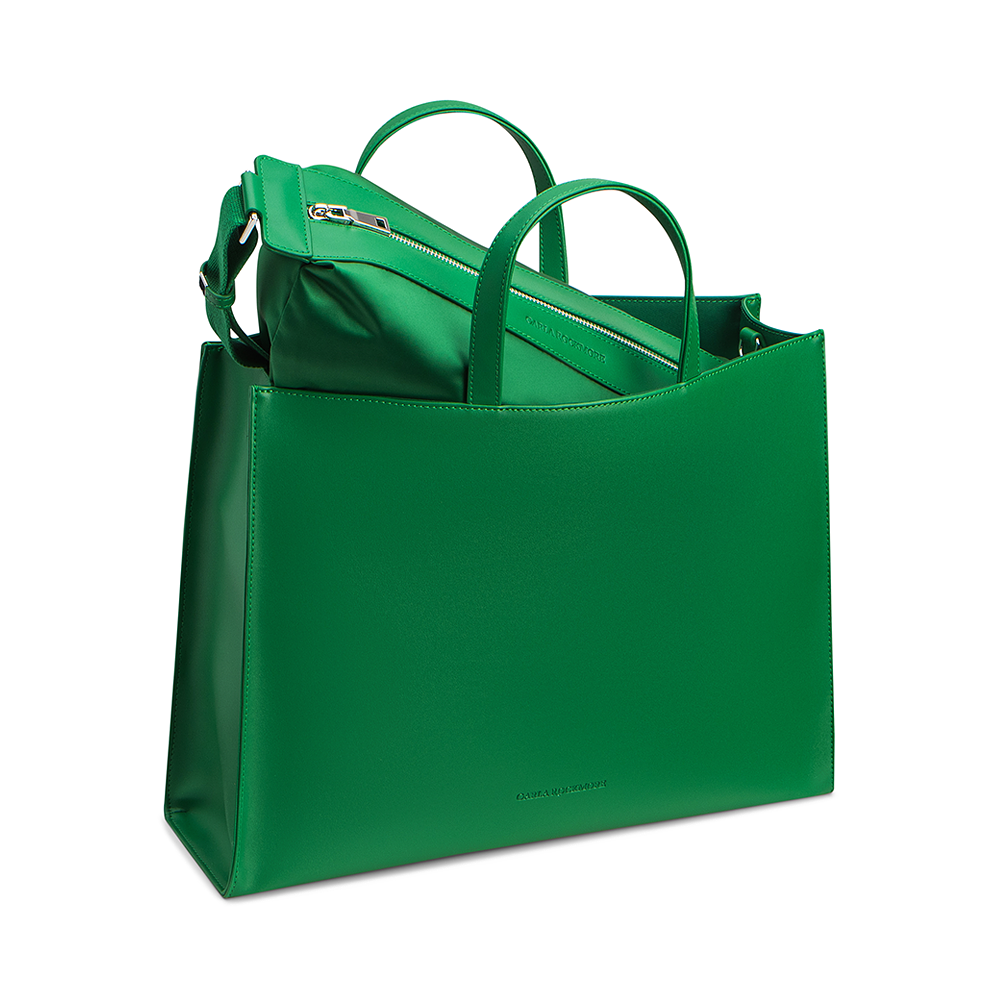 Close up of the emerald green Tote with the matching detachable mini sling bag coming out of the bag on a white background.