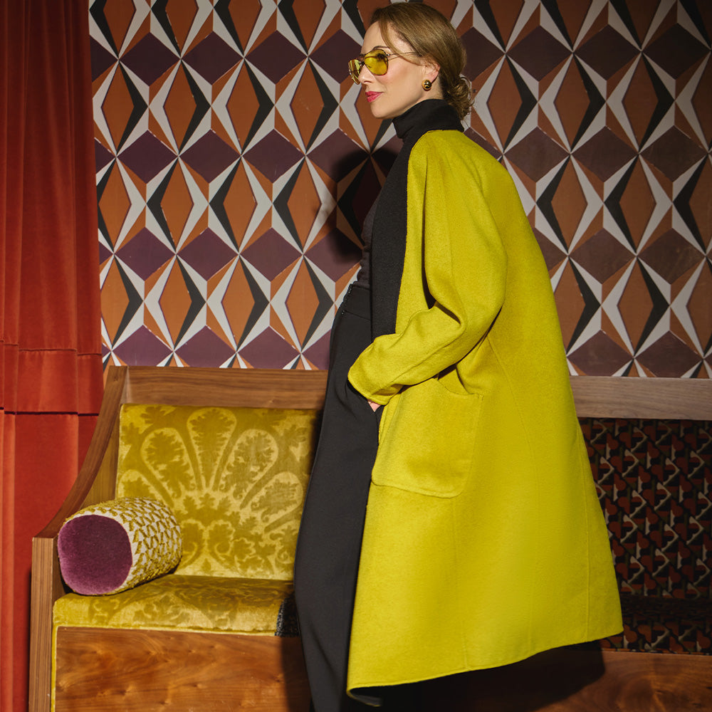 Carla modeling the side and the back of the coat in Moss.