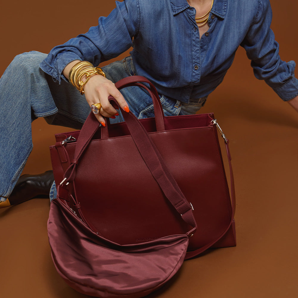 Model holding the 2-in-1 Tote bag is Cherry Cola against a brown background.